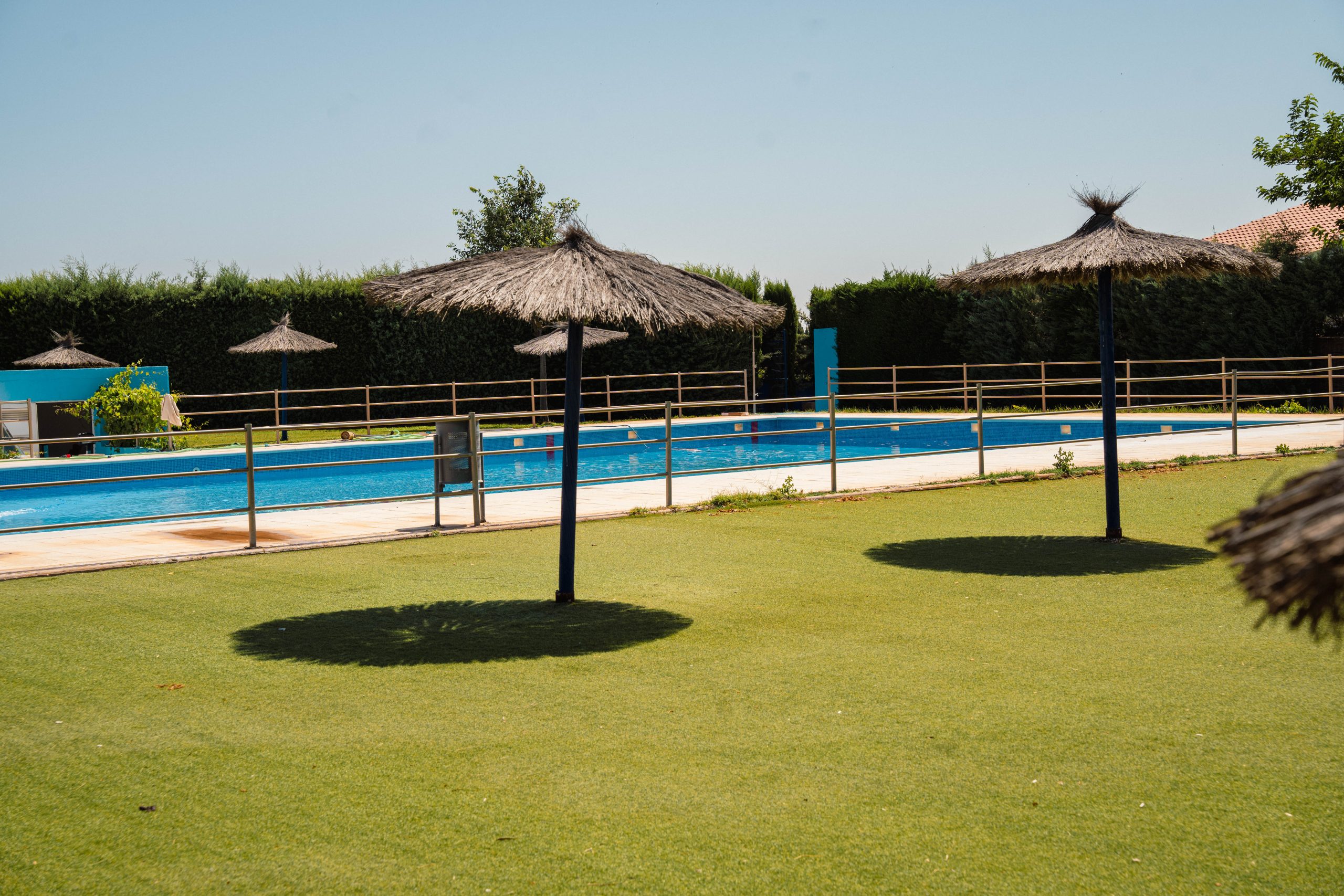 Piscina municipal de Las Labores con sombrillas dispuestas en la zona de descanso. Fotografía realizada por Ikonox.